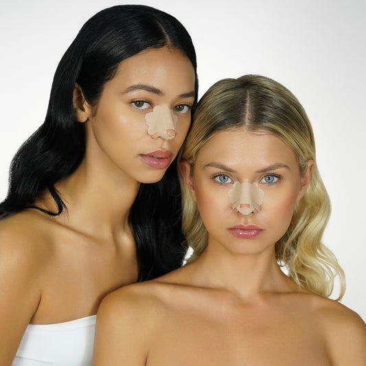 Two women with beige 'recovery babe' pre-cut rhinoplasty nose strips on their noses against a white background