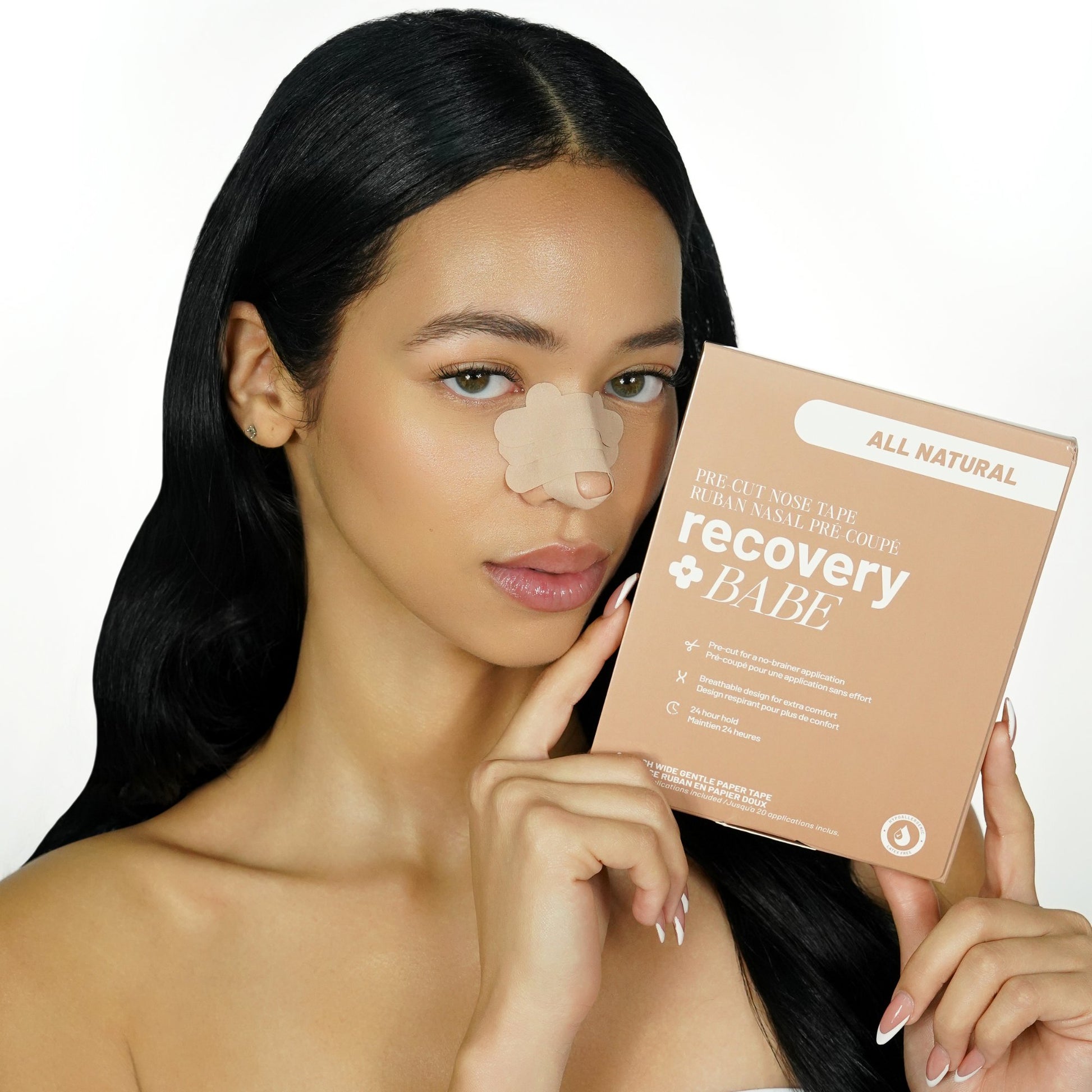 Woman with beige pre cut adhesive rhinoplasty nose strips on her nose, holding a 'recovery BABE' product box.